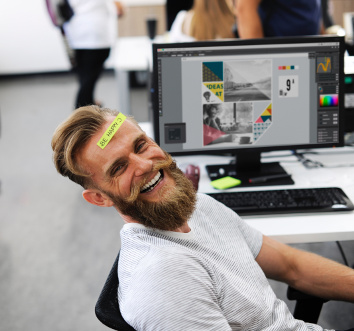 Ein Mann mit Bart sitzt im Büro