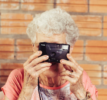 Eine ältere Frau macht mit einer Kamera ein Foto